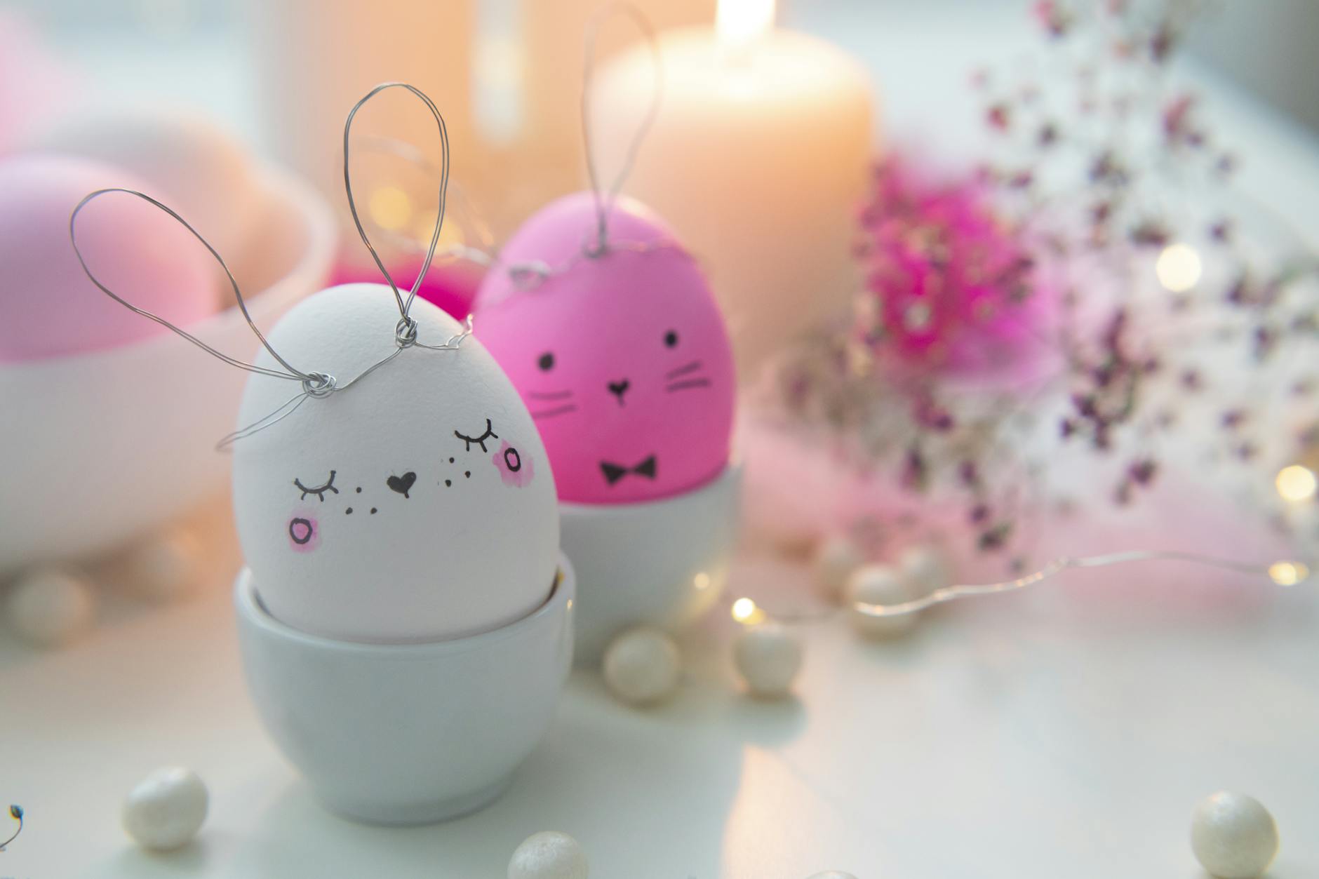 pink eggs and white candles on white table